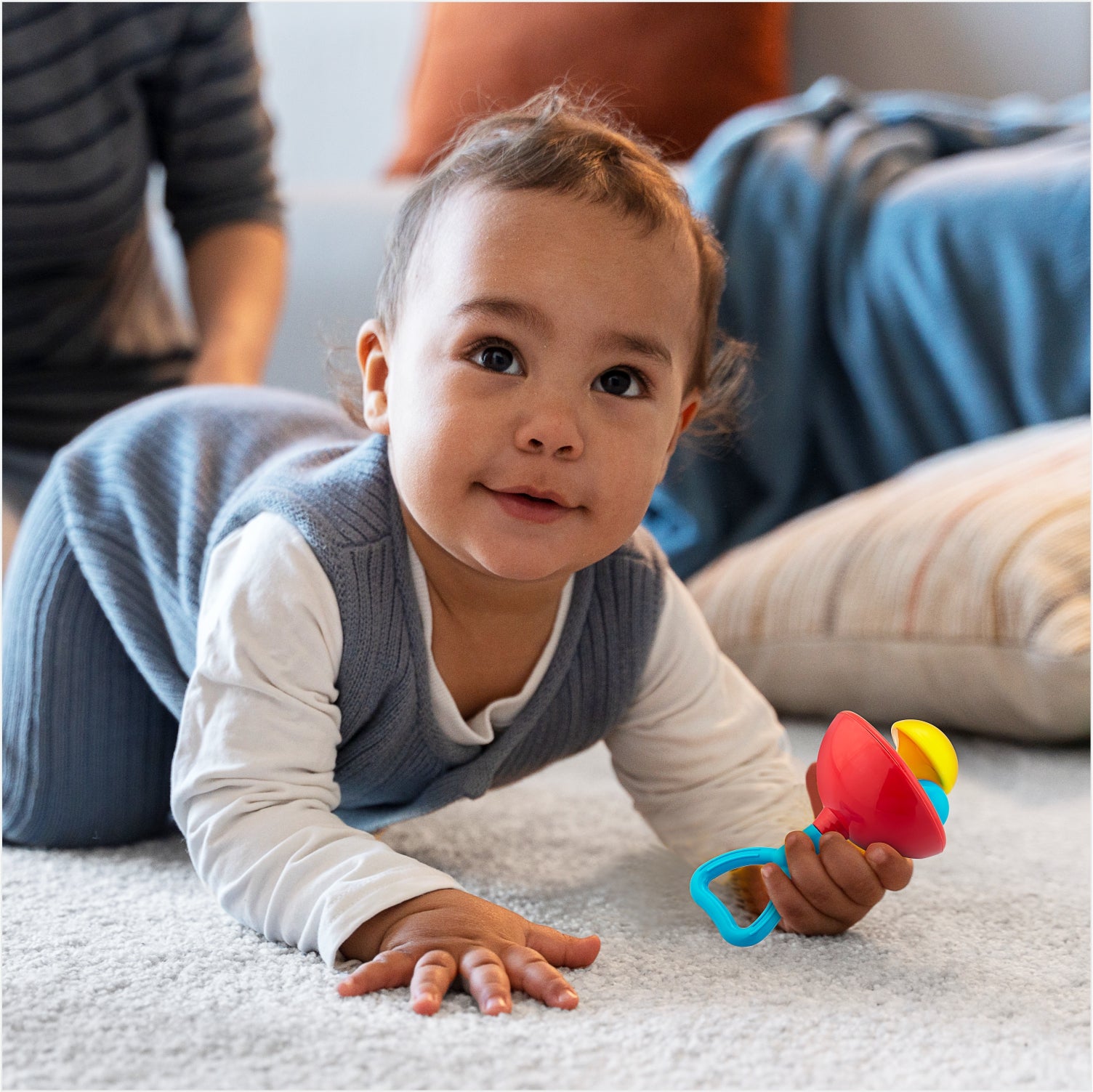 kid playing with rainbow rattles 
